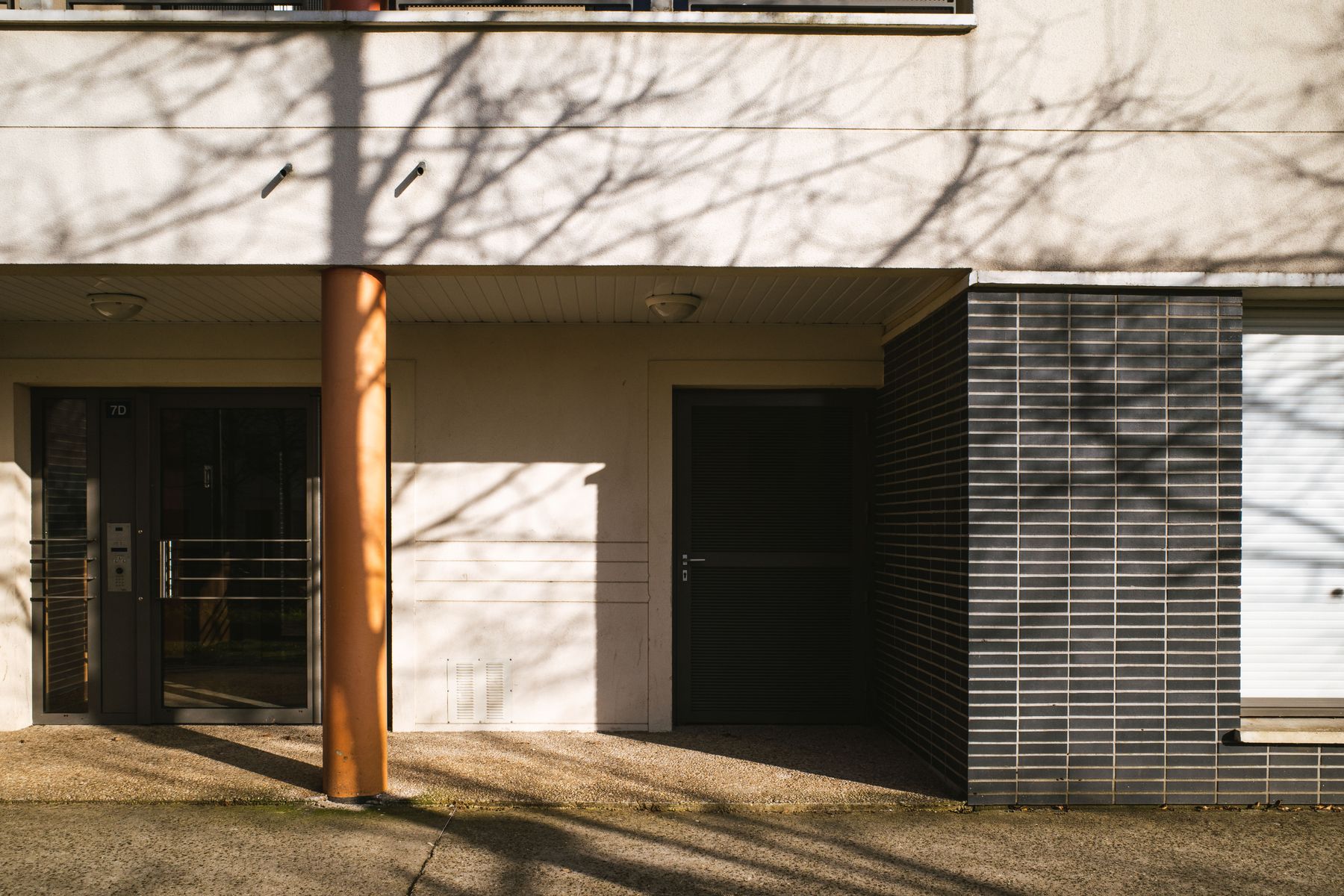 A entrada do prédio do consultório, em Perdizes, sob o sol da tarde.