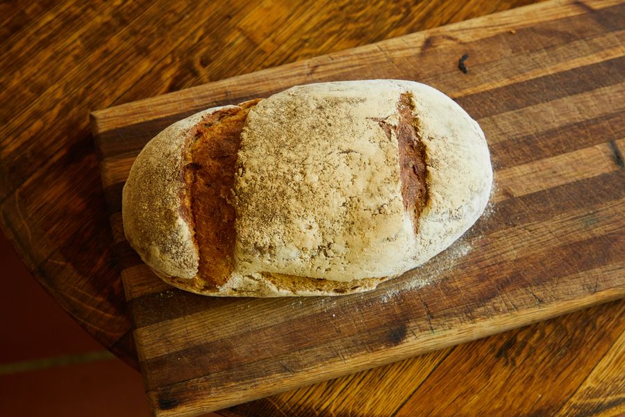 Pão rústico recém-assado sobre tábua de madeira