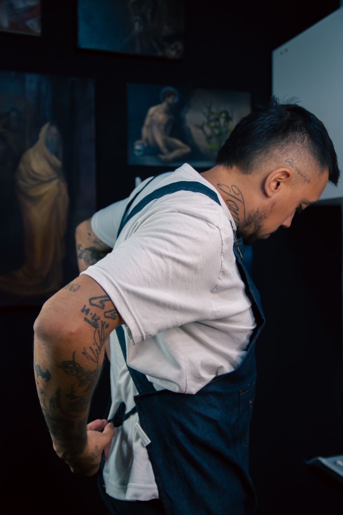 Chef de avental na cozinha à meia-luz, ajustando o preparo