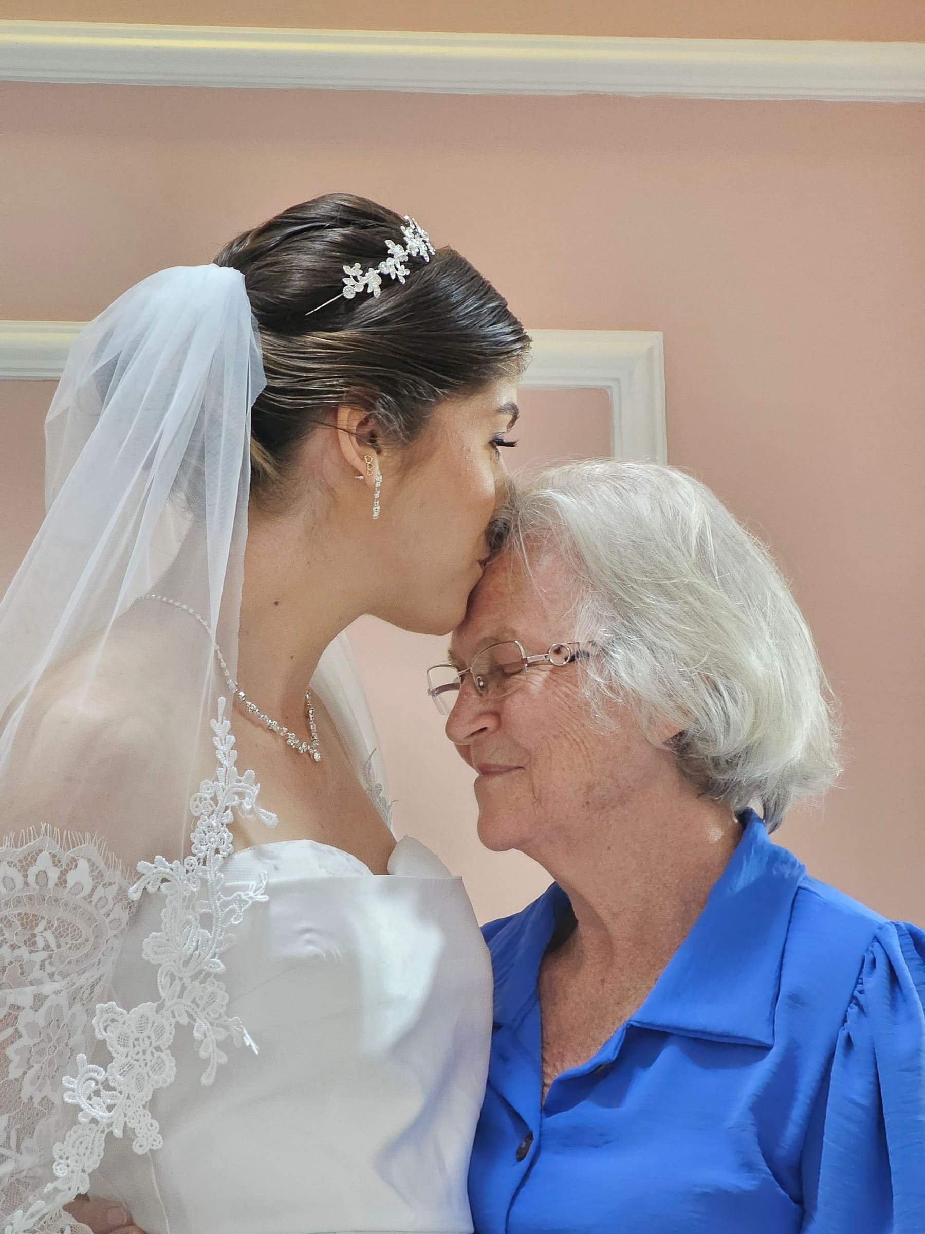 A noiva beijando a testa da avó, num momento emocionado antes da cerimônia.