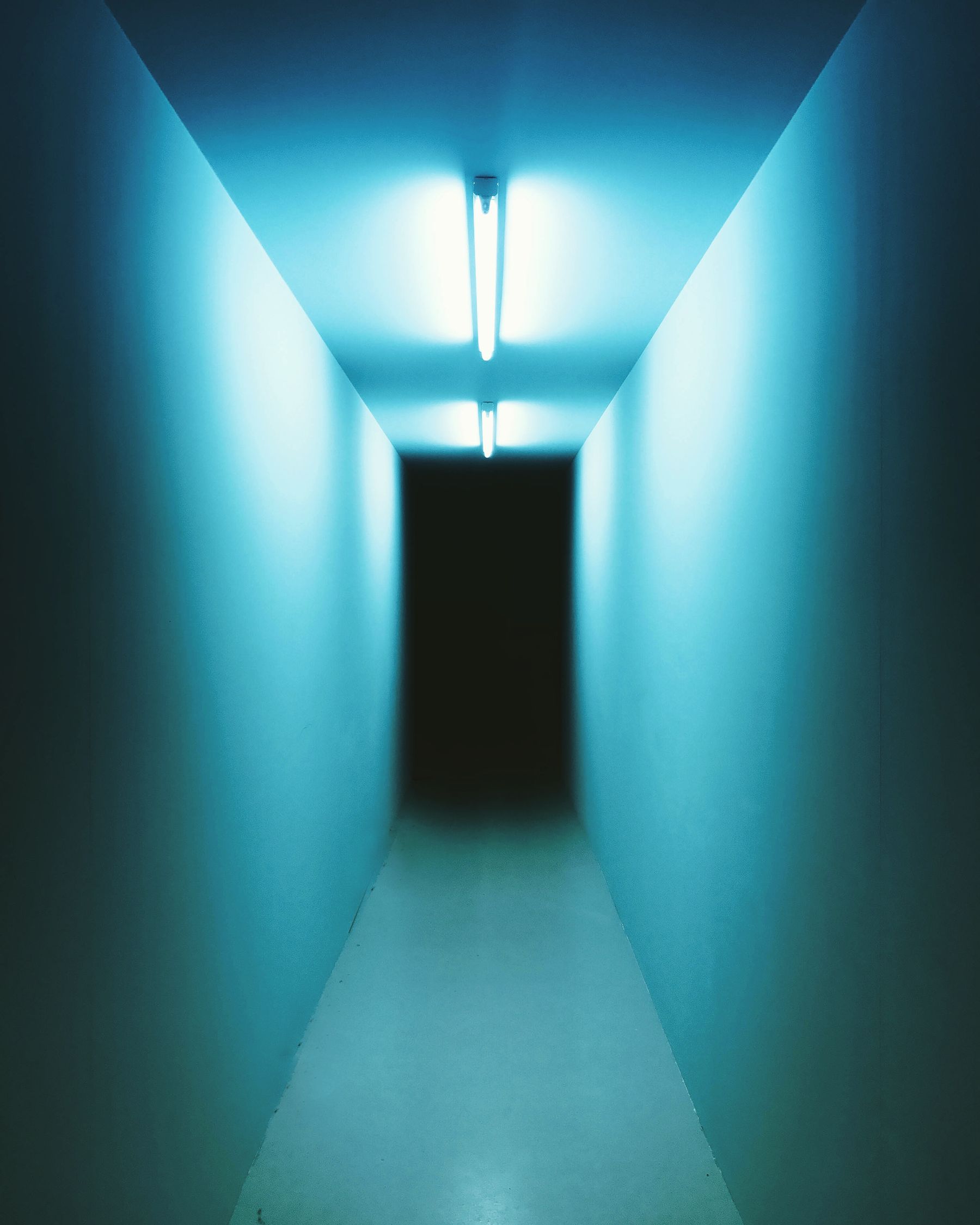 A cabine de atendimento à meia-luz, com o brilho azul do aparelho de LED.