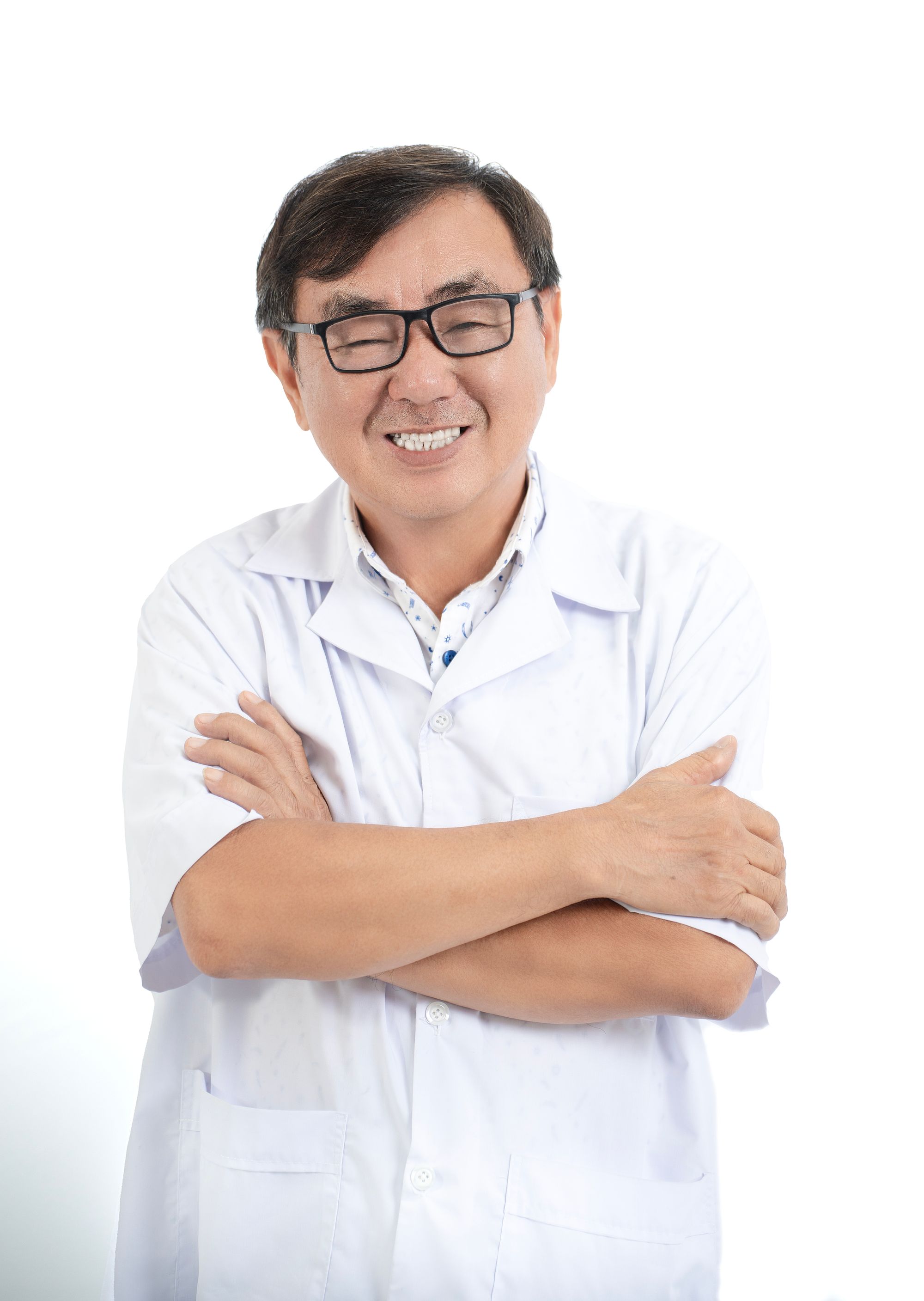Dr. Henrique Salles, de jaleco, sorrindo à luz da janela da clínica.
